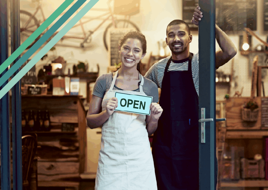 Business owners holding an open sign.